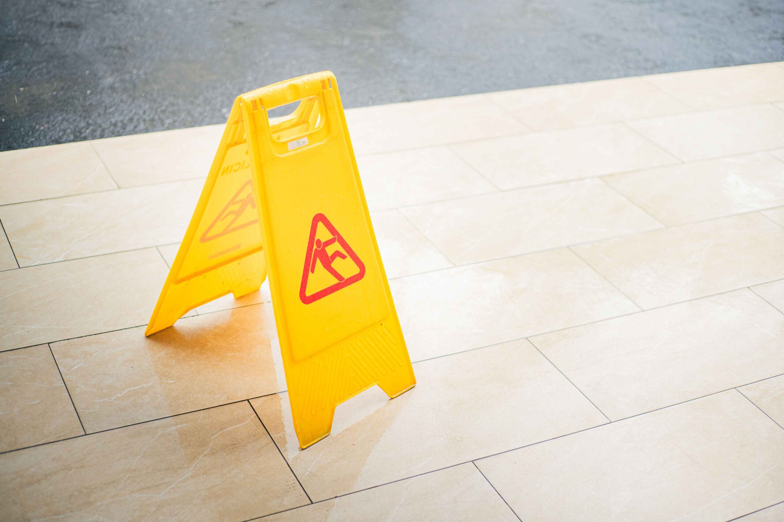 Wet floor caution sign inside a store, representing slip and fall accidents in Durham and Chapel Hill